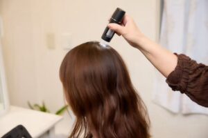 女性の頭皮をマイクロスコープで撮影している場面
