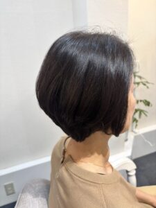 後頭部にふんわり丸みを持たせ、襟足をすっきり仕上げた横向きの40代女性のひし形ショートボブ