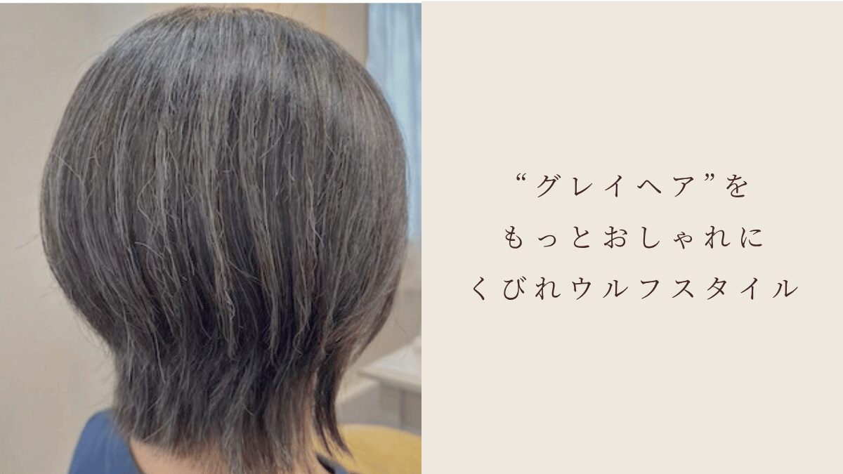 Back of a person’s head with short gray layered hair; beige panel on the right shows Japanese text about stylish gray-hair wolf style.